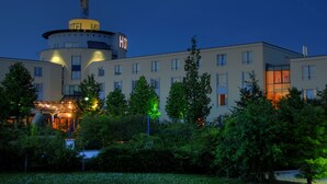 A hotel with a central tower labeled "HOTEL MESS" and a modern building with multiple windows. - Hotel Meerane (Meerane)