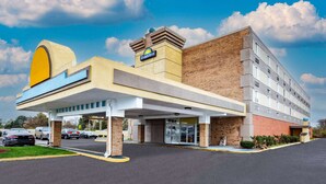 Un hôtel avec une enseigne distinctive, un parking couvert et une façade en briques.