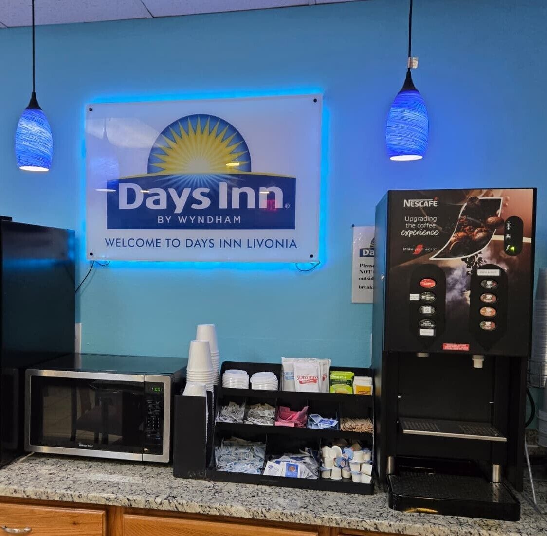 Señalización de Days Inn, una cafetera y un microondas sobre una encimera.