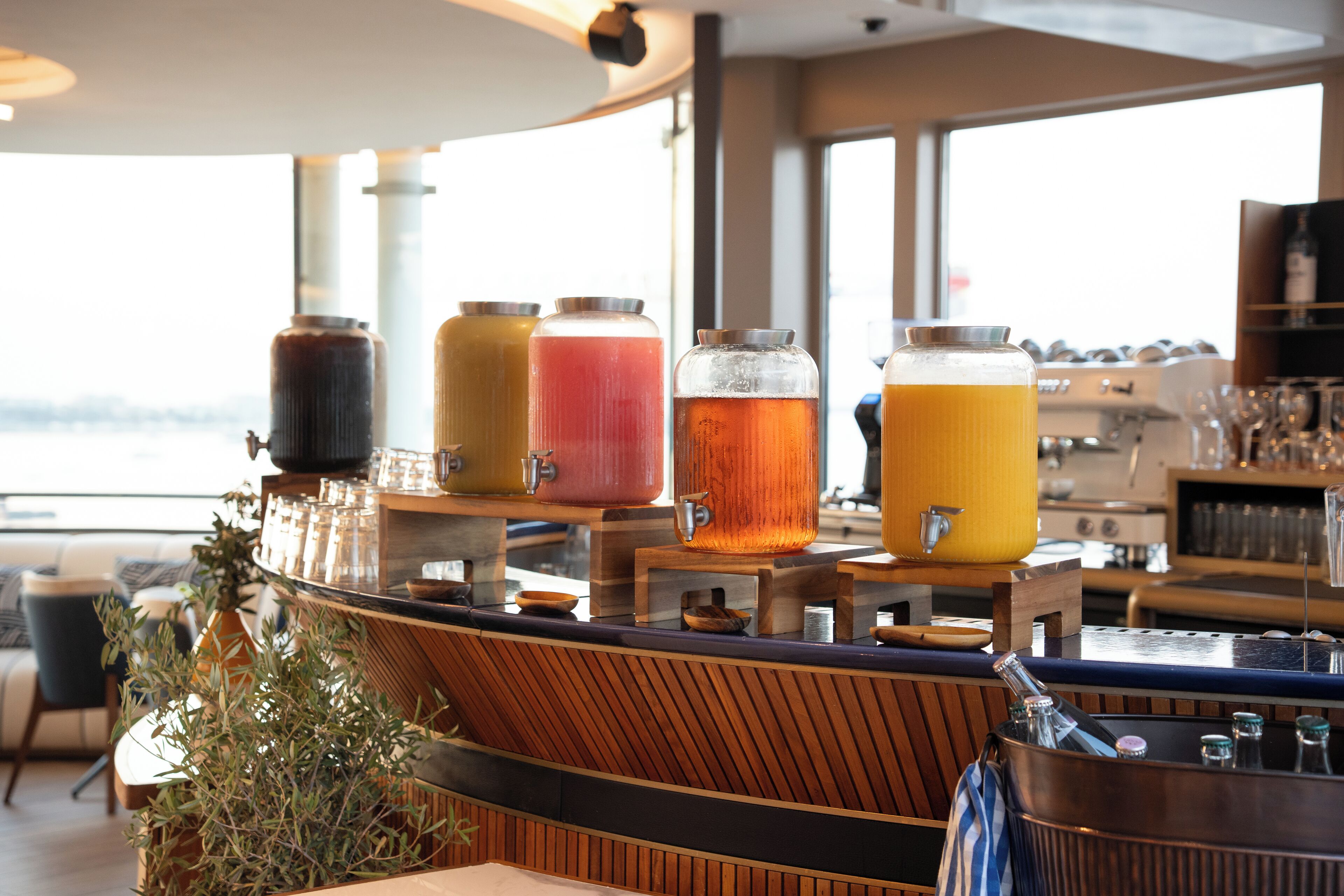 Un espace bar doté de plusieurs distributeurs de boissons et offrant une vue sur la mer.