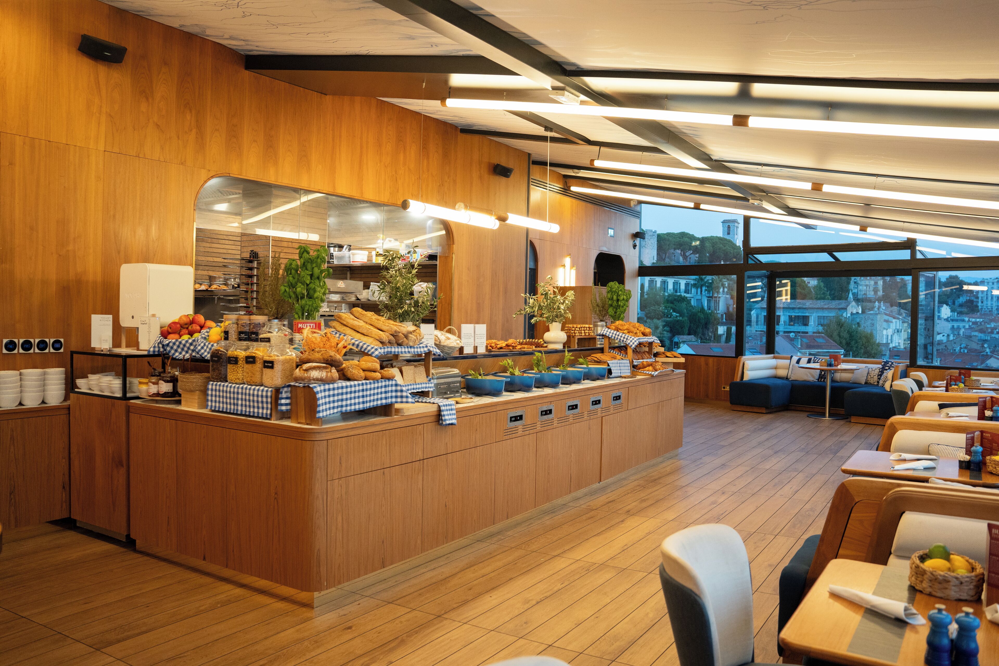 Un banco della colazione con diversi cibi e un'area salotto con tavoli e sedie.