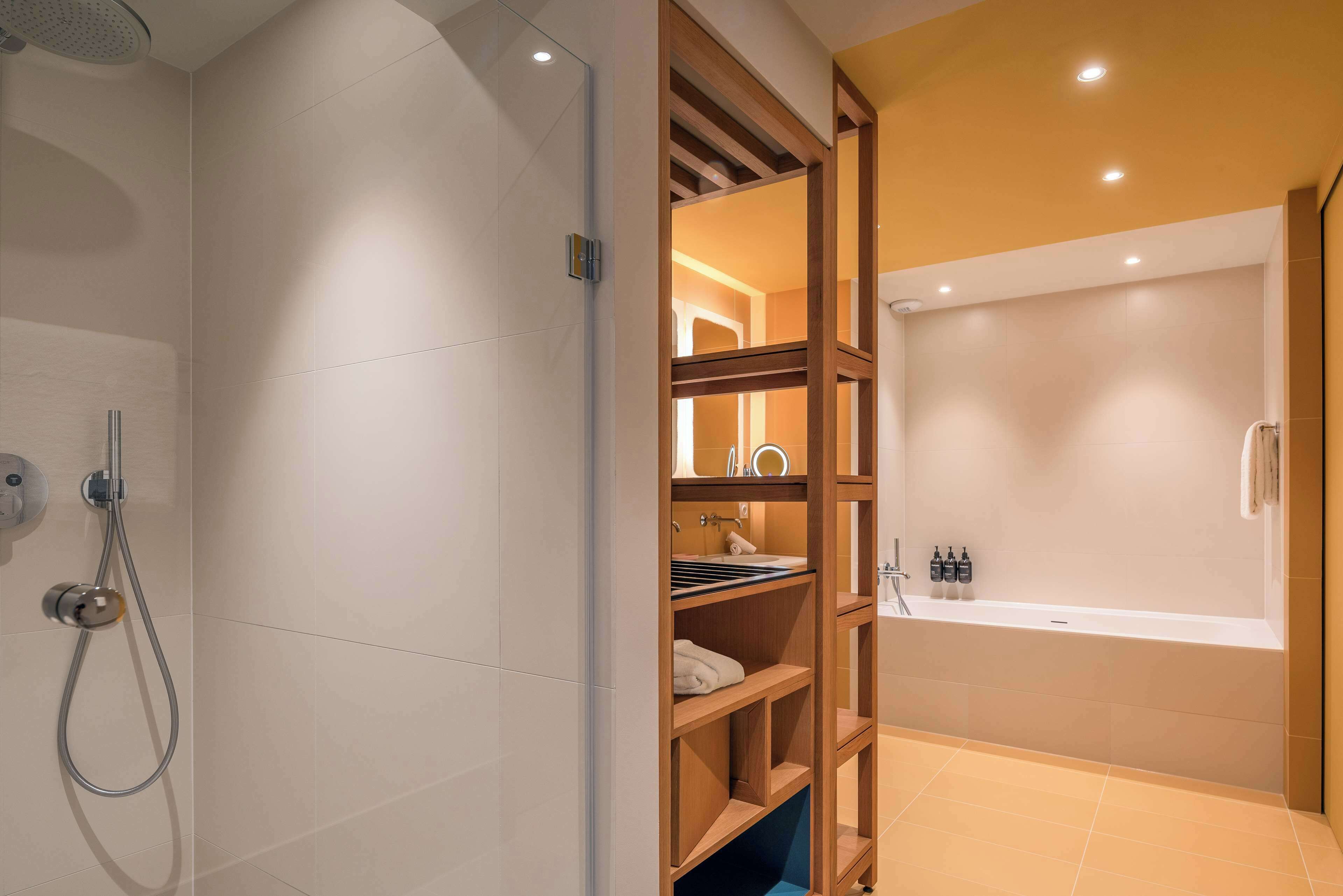 A modern bathroom with a shower, a bathtub, and a wooden vanity with shelves.