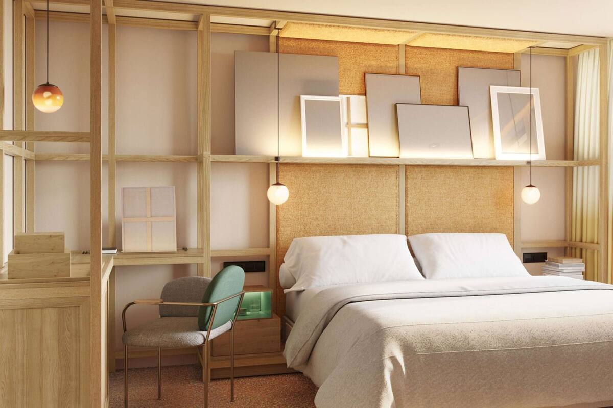 A bedroom with a bed, a desk, a chair, and shelves with framed pictures.