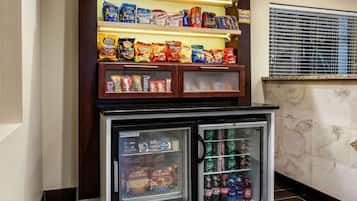 Máquina expendedora con snacks y bebidas, incluyendo Doritos y Coca-Cola.