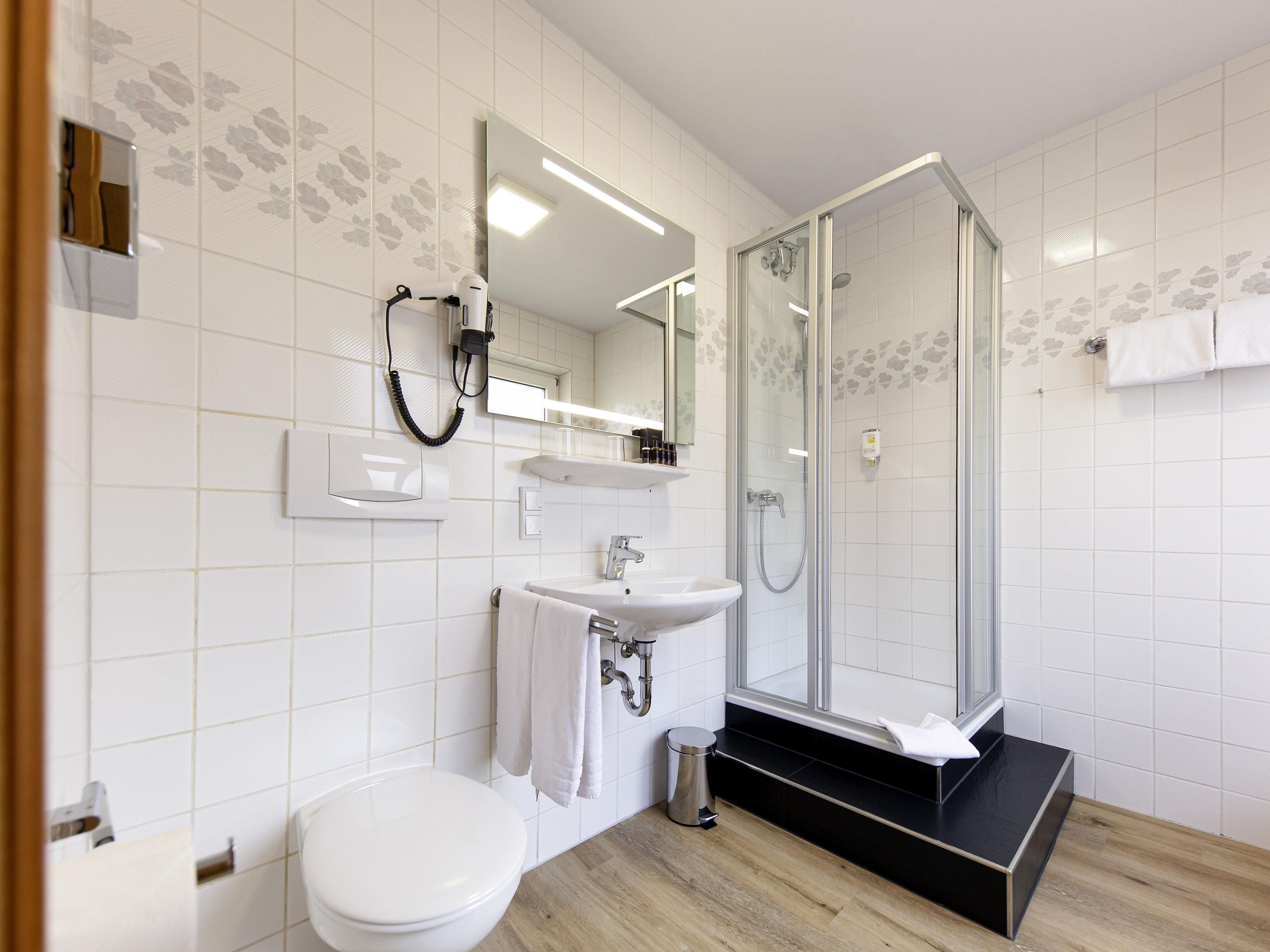 Un bagno moderno con il water, un lavandino e una cabina doccia in vetro.