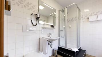 Un bagno moderno con il water, un lavandino e una cabina doccia in vetro.