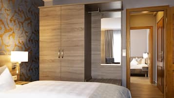 Ein Hotelzimmer mit Bett, Schrank und Blick in einen anderen Raum.