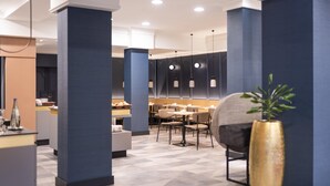 A modern dining area with high ceilings, dark blue walls, and geometric patterned flooring. - Mercure Hotel Mainz City Center (Mainz)