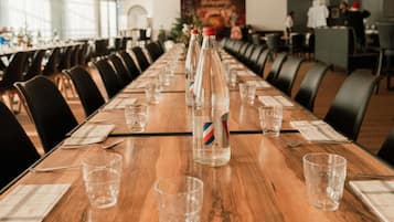 A conference room with long tables, chairs, and water bottles.