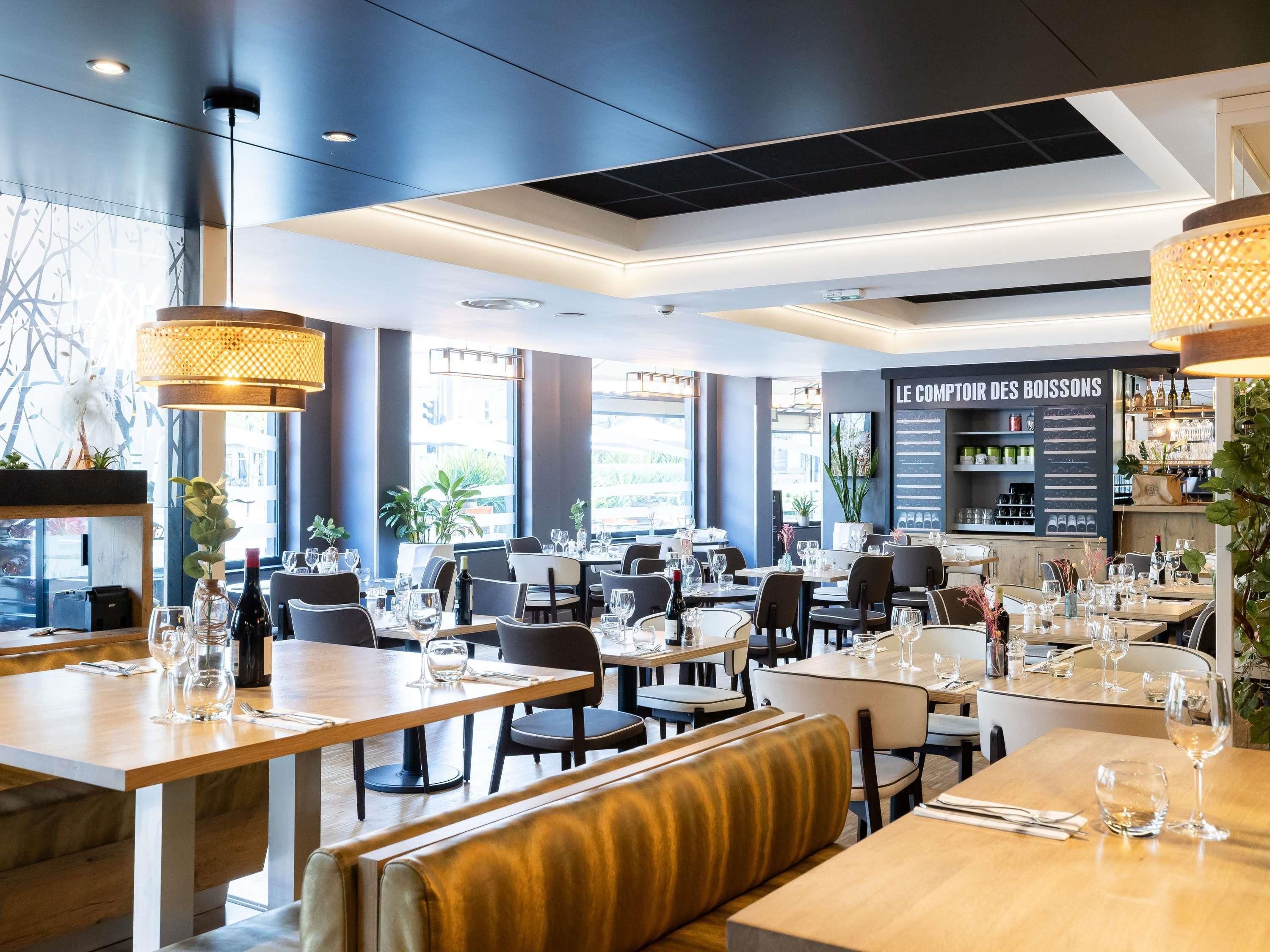 Interior de un restaurante con mesas, sillas y una pizarra de menú.