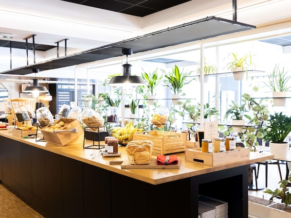 Eine Bäckereitheke mit verschiedenen Backwaren und Zutaten, umgeben von Blumentöpfen und einem modernen Innendesign.
