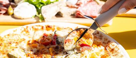 Une pizza garnie de divers ingrédients est servie.