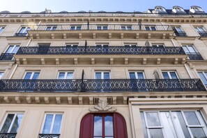 Un immeuble à plusieurs étages, doté de balcons richement décorés et d’un style architectural classique.