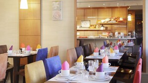 A restaurant with multiple tables set for dining, each with a white cup, saucer, and napkin. - Hôtel Londres et New York - Teritoria (Paris)