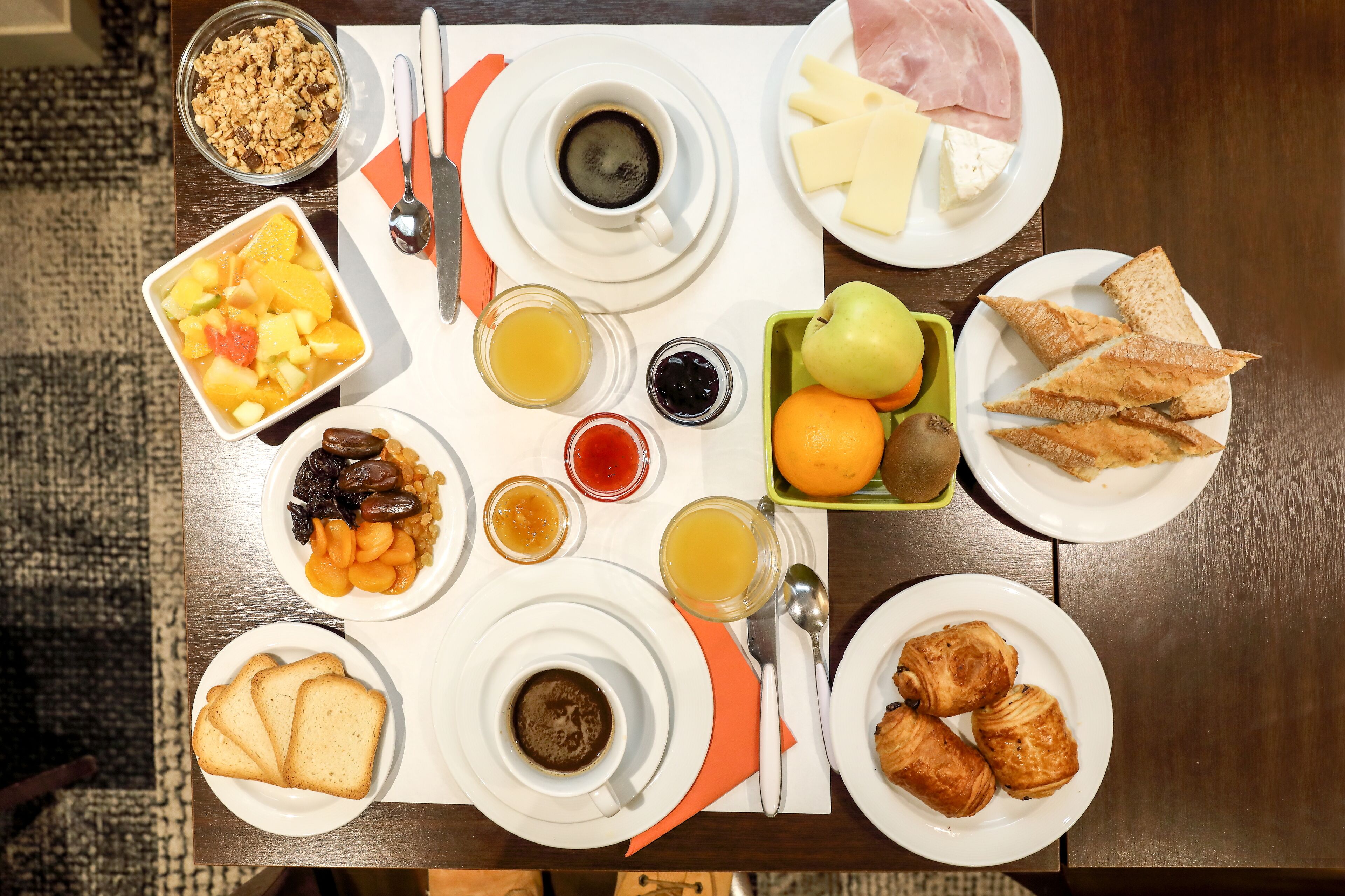 A breakfast table with various food items and drinks.