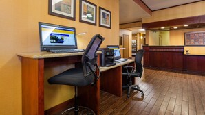 A reception area with two HP computers, a printer, and a counter with a keyboard.