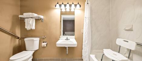 A bathroom with a toilet, sink, and shower.