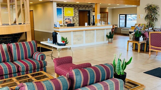 Eine geräumige Lobby mit gestreiften Sofas, einem Empfangsschalter und einer Kandelaber.