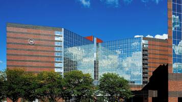 A modern building with a glass facade, a brick base, and a prominent logo on the side.