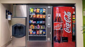 Máquina expendedora con aperitivos y un dispensador de Coca-Cola.