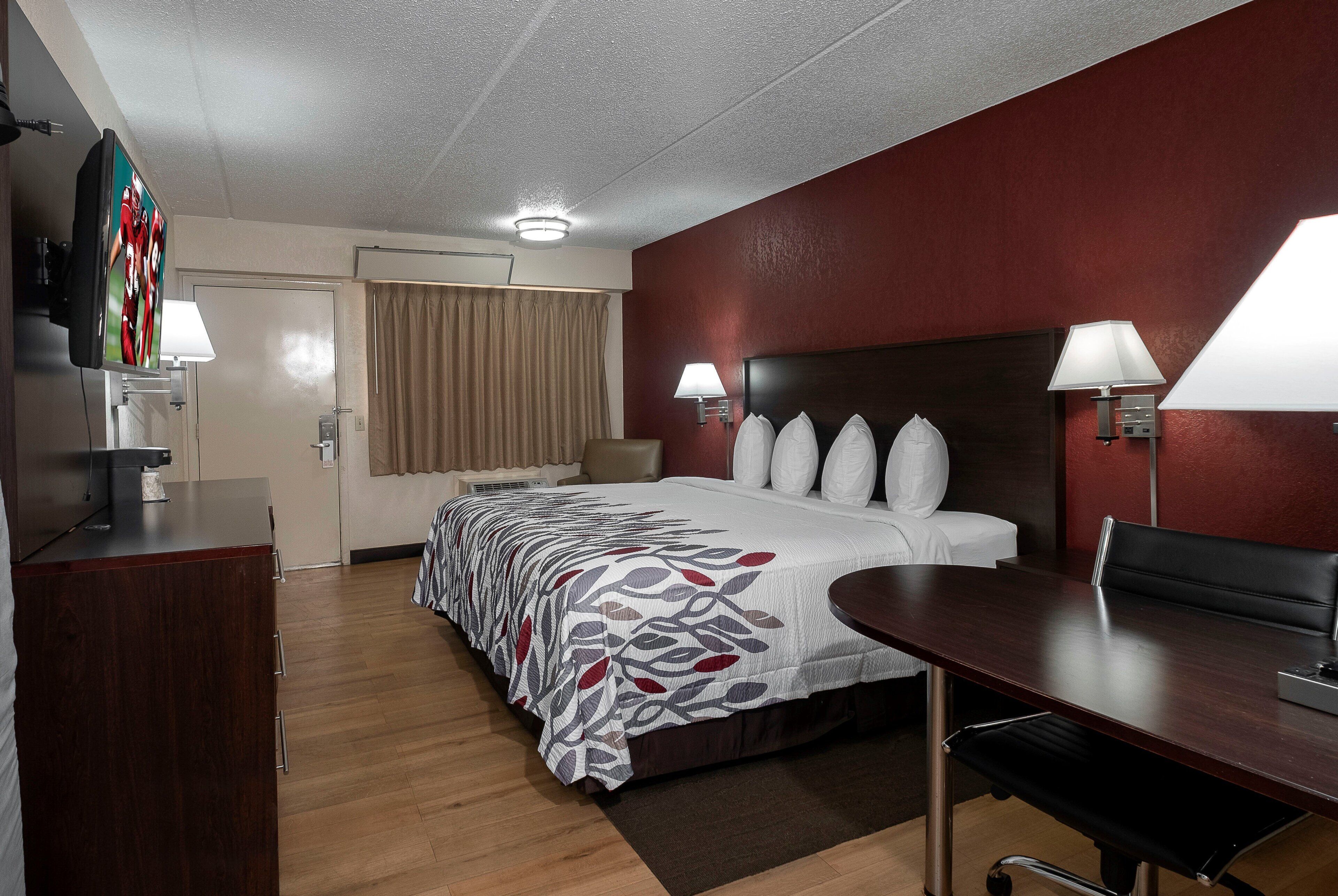 Une chambre d’hôtel équipée d’un lit, de lampes de chevet, d’un bureau et d’une télévision.
