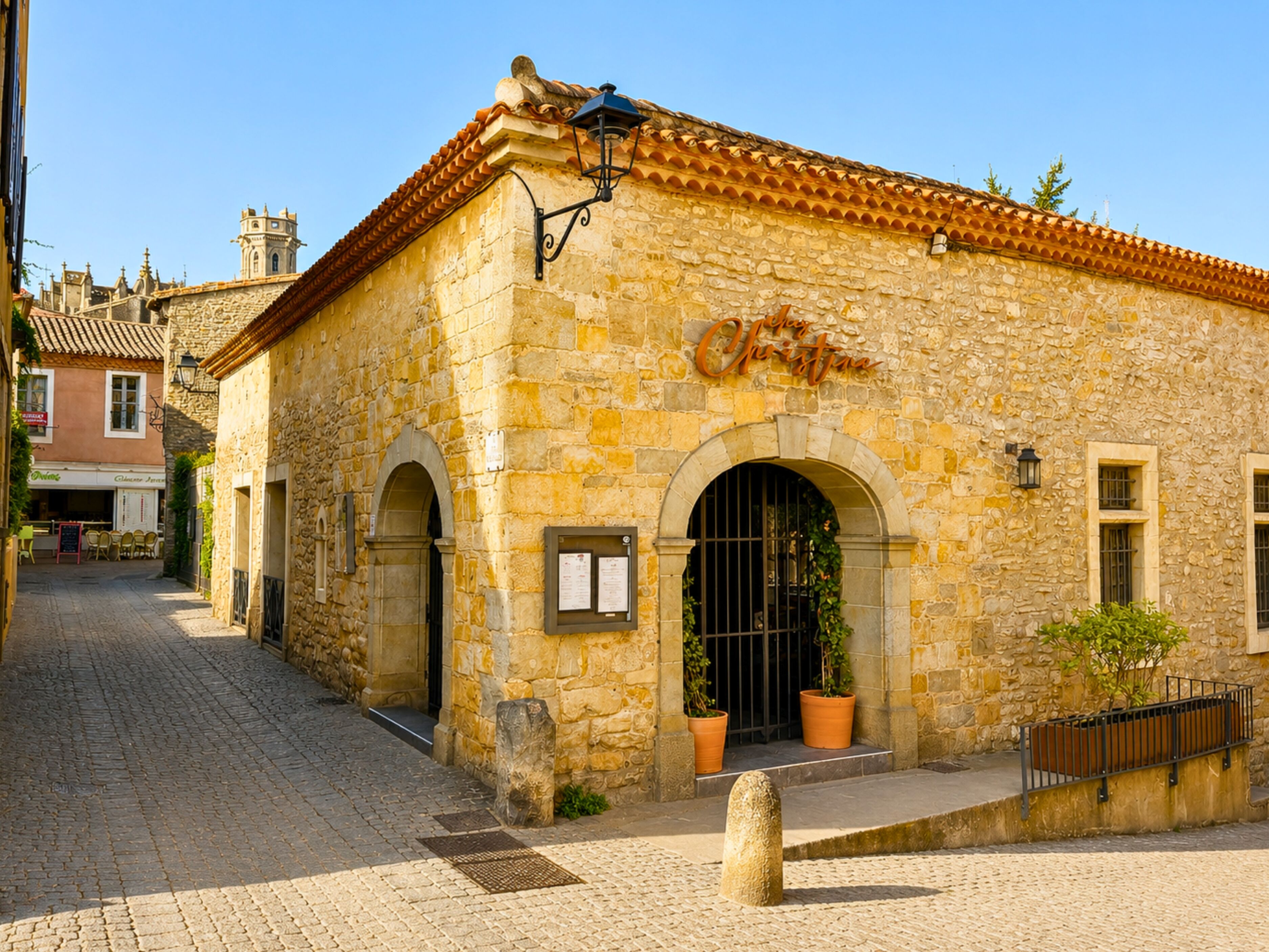 A stone building with a tiled roof, arched doorways, and a sign that reads 'Chiesa di Cristo.'