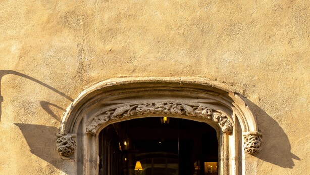 A stone entrance with an ornate archway leading into a building.