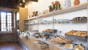 A breakfast buffet with various pastries, bread, and condiments.