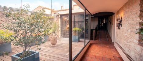 A modern interior with a wooden deck, potted plants, and a stone wall.