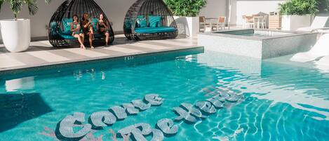 Una piscina al aire libre, camas de piscina gratis, sombrillas