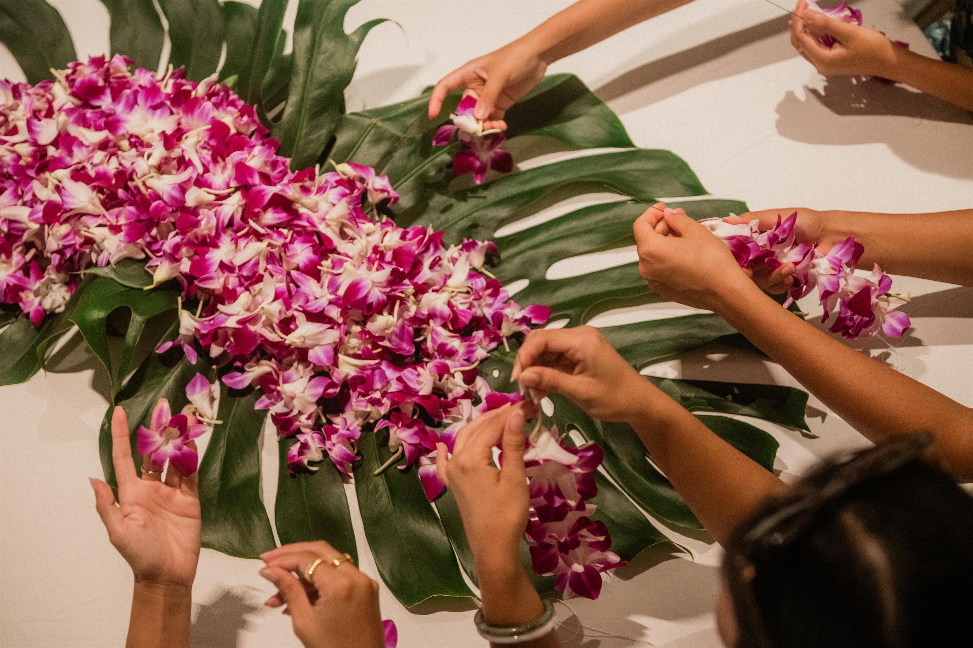 Un grupo de personas disponiendo flores sobre una mesa.