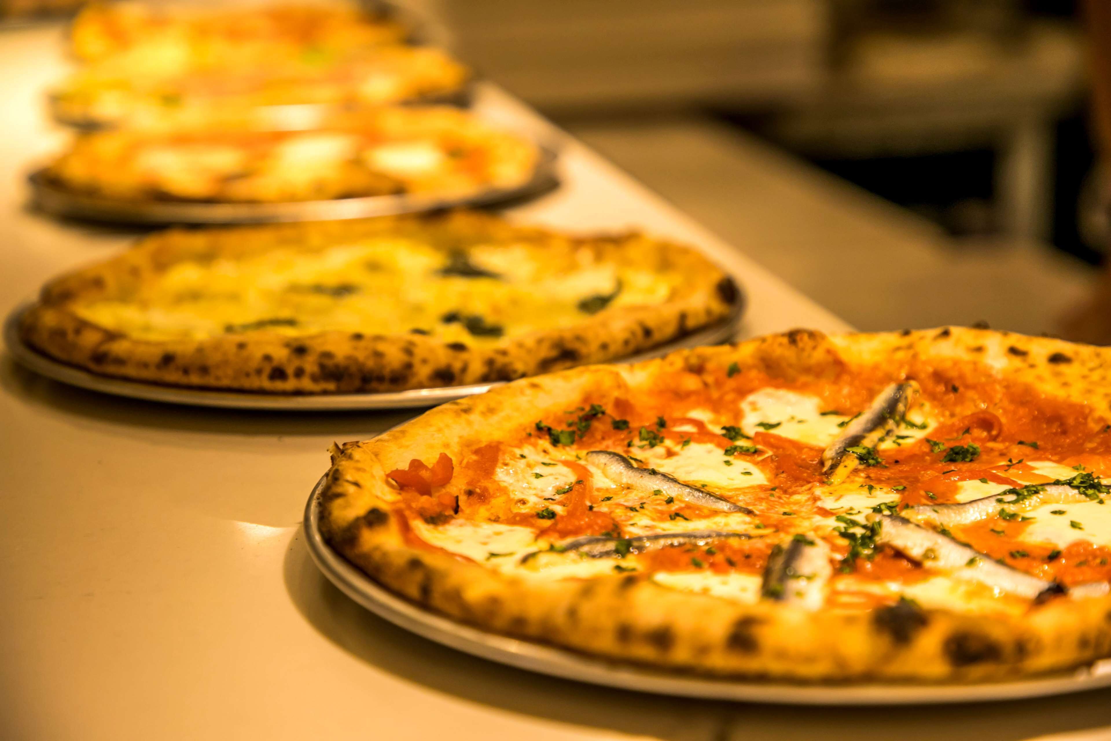 Een rij pizza's op een tafel.