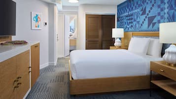 A hotel room with a bed, bedside tables, a TV, a painting, and a view of the city.