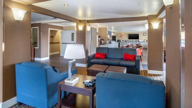 A modern hotel living room with a sofa set, a coffee table, and a lamp. - Comfort Inn Castro Valley (Castro Valley)