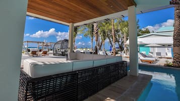 Un espace extérieur aménagé, abrité et doté d’une piscine, de chaises longues et d’une vue sur l’océan.