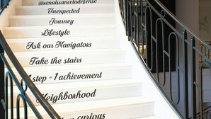 A spiral staircase with motivational phrases on the steps. - Renaissance Paris La Defense Hotel (Puteaux)