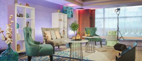 A modern living room with a sofa, armchairs, a coffee table, and a bookshelf.