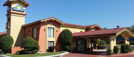 A Days Inn with a red-tiled roof, a central entrance, and a parking lot.