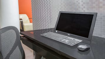 A computer desk with a Dell laptop, keyboard, and mouse.