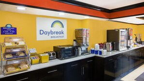 Ein Frühstücksbereich mit einem Schild für Daybreak Breakfast, einer Kaffeemaschine, einer Mikrowelle und verschiedenen Speisen.