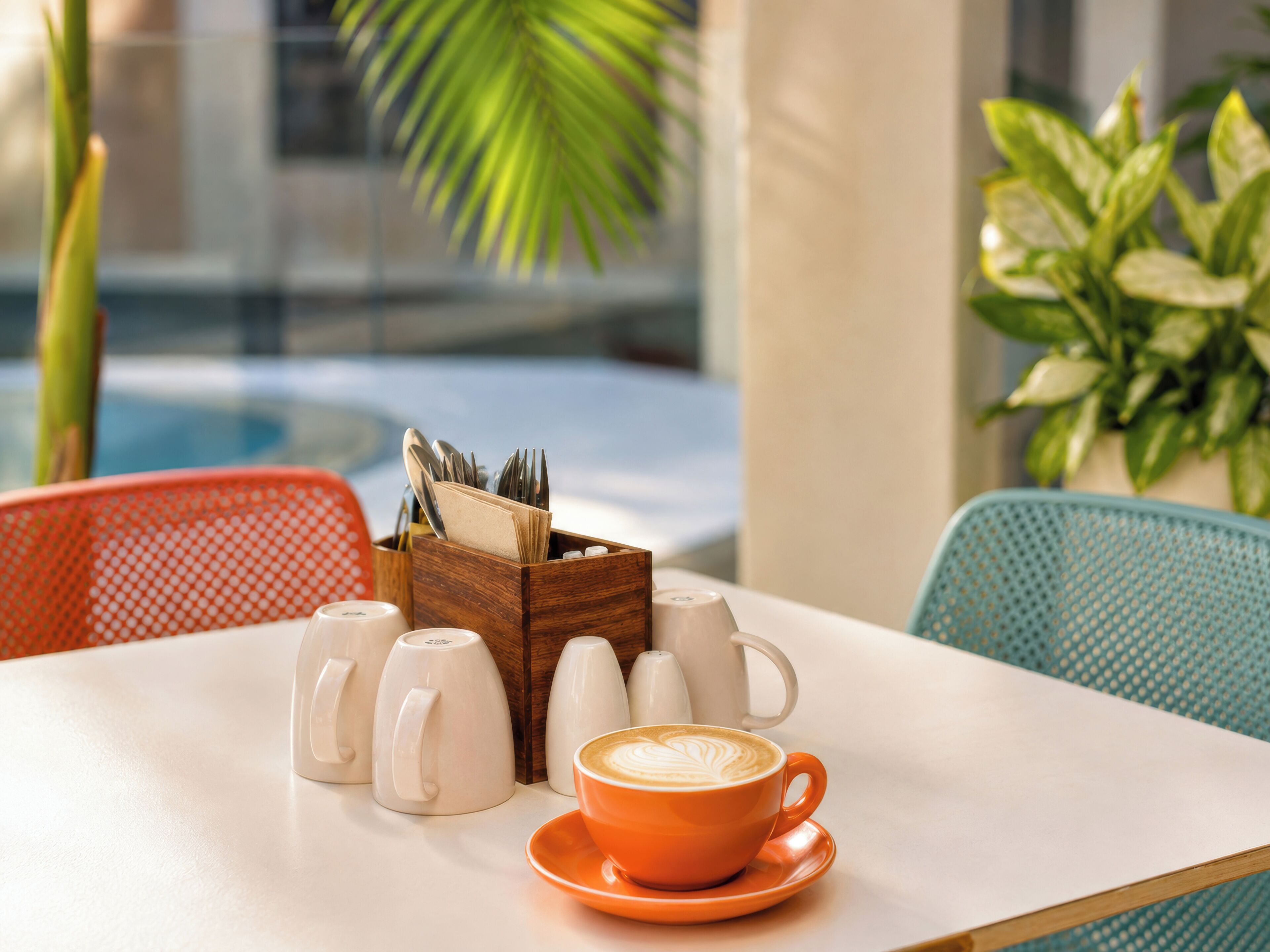 A table with a coffee cup, sugar cubes, and a napkin holder.