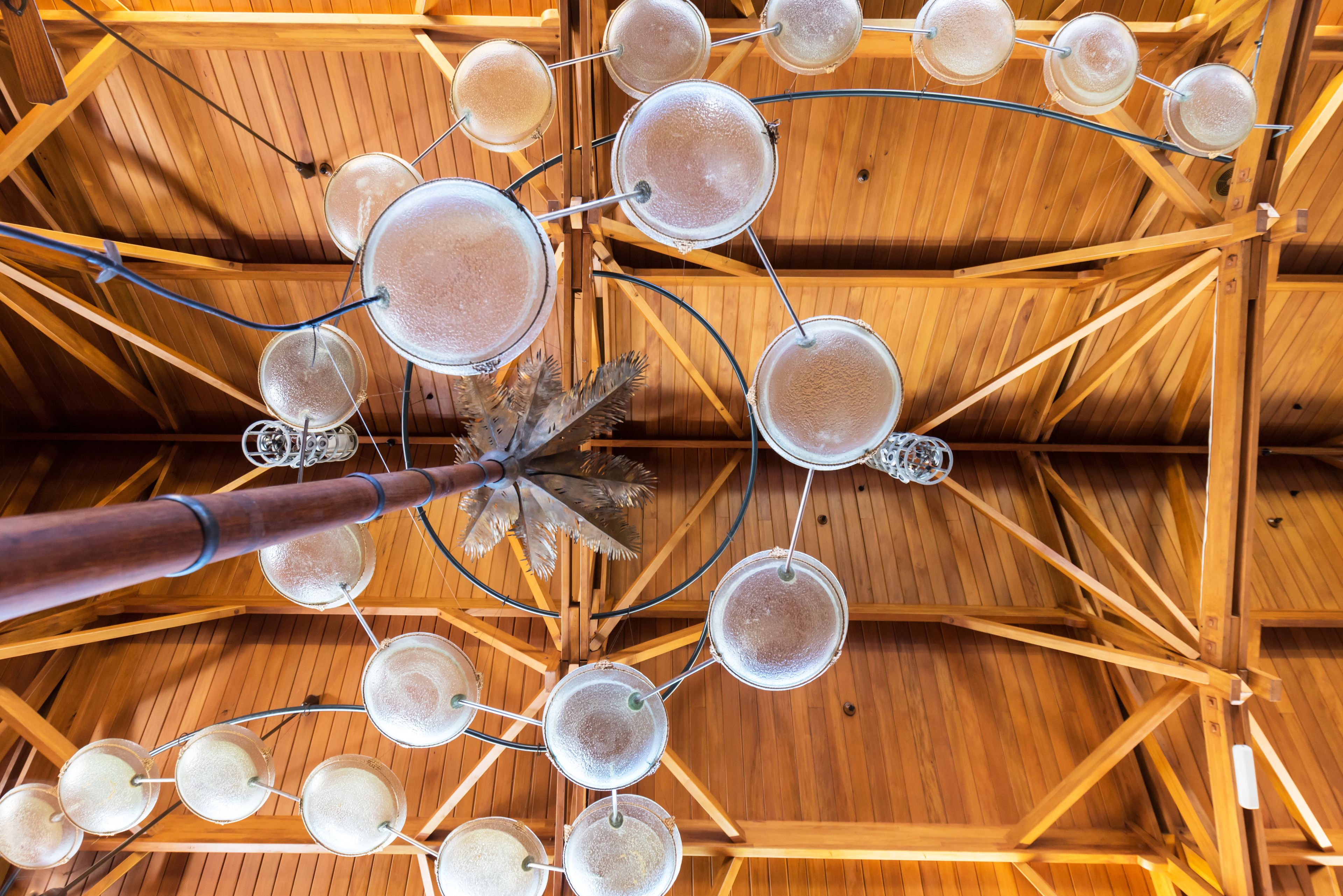 Un plafond doté d’une structure en bois et de plusieurs récipients en verre.