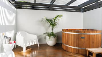 Relax in a serene spa area with a hot tub, chair, and potted plant.