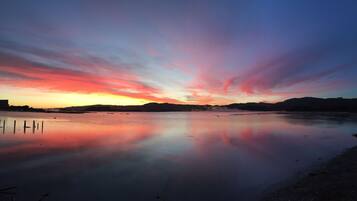 A calm lake at sunset with a clear reflection of the sky.