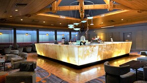 A lobby with a marble reception desk, seating area, and wooden ceiling.