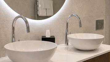 A bathroom with two vessel sinks, a mirror, and a towel rack.