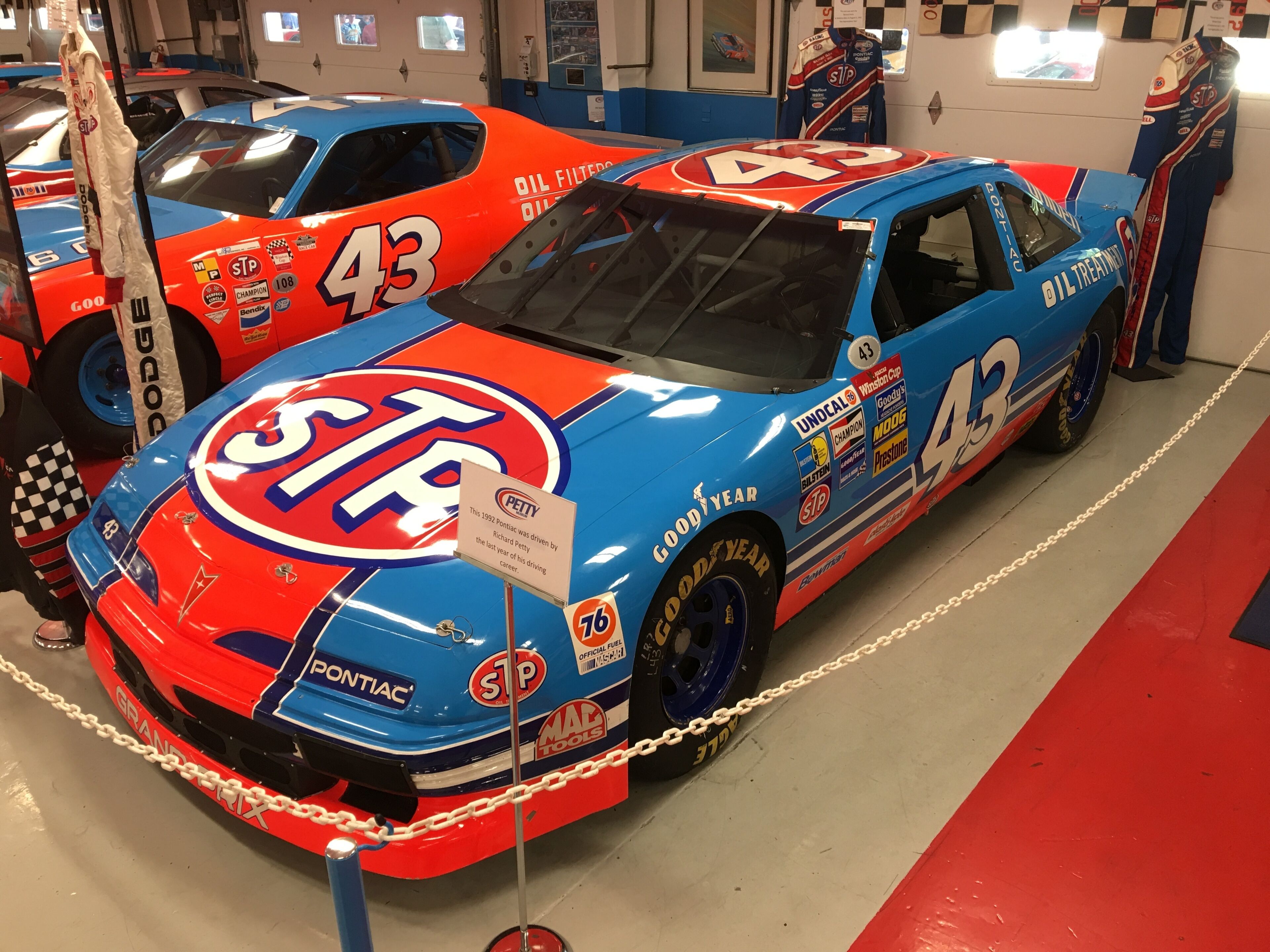 A vintage race car with the number 43, displayed in a museum or exhibition setting.