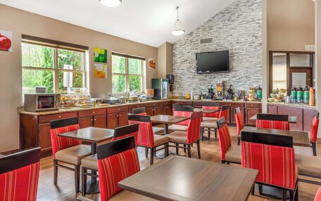 A restaurant with a stone wall, a flat-screen TV, and a buffet area.