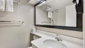 A bathroom with a white sink, a mirror, and a towel rack.