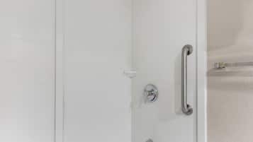 A shower with a handheld showerhead, a handheld showerhead, and a handheld showerhead.